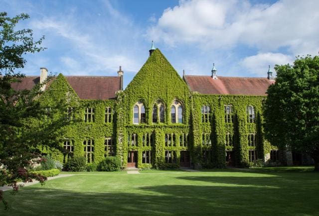 Ivy-covered building with green lawn at Cheltenham Ladies College