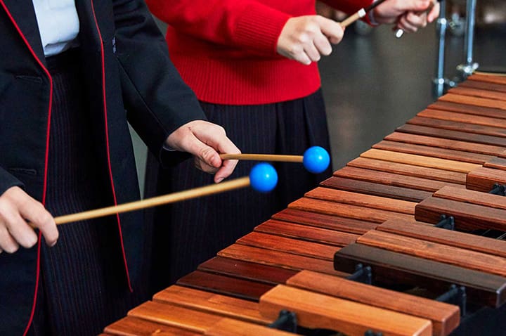 Two children playing a wooden xylophone